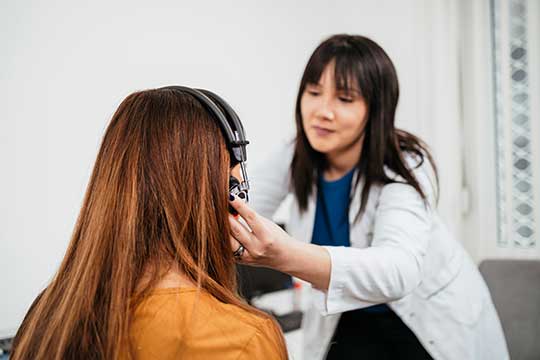 A woman being tested for auditory processing disorder