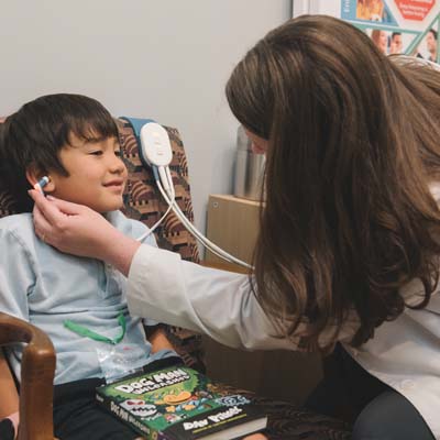 Testing for Auditory Processing Disorder (APD) with a child in office.